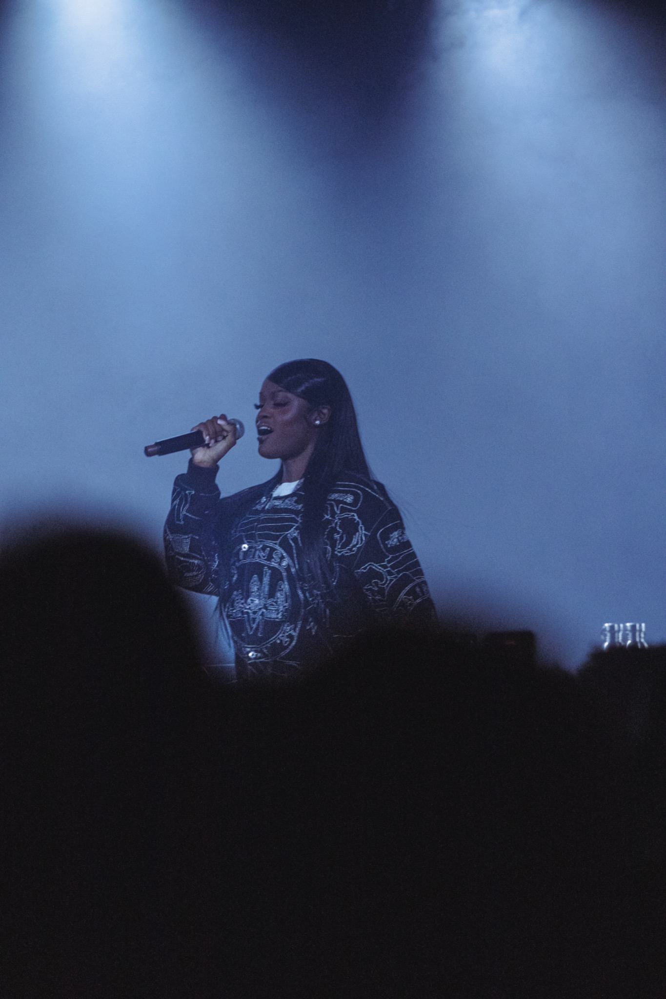 Chanteuse en performance sous une lumière bleue