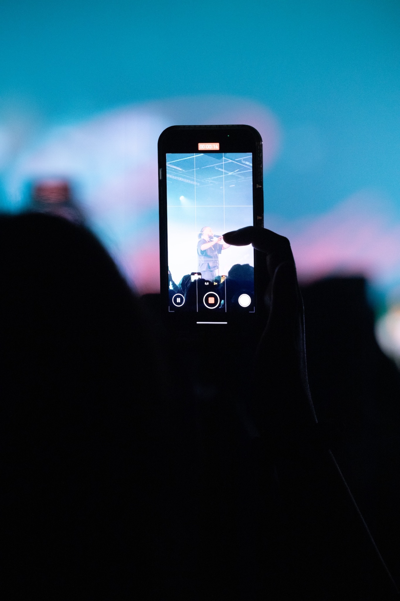 Concert filmé au téléphone sous une lumière bleue