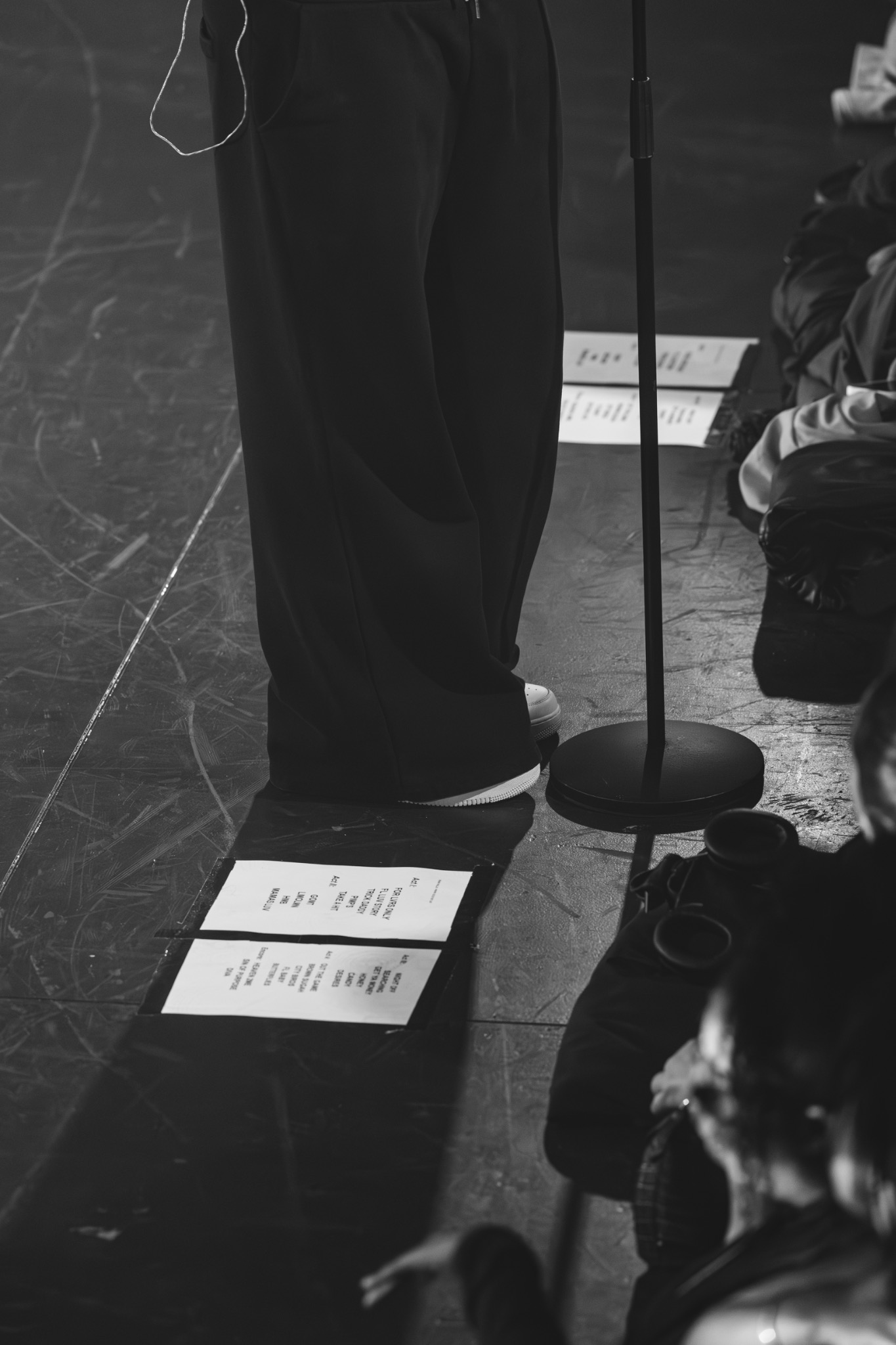 Détail de scène et feuilles de setlist en noir et blanc