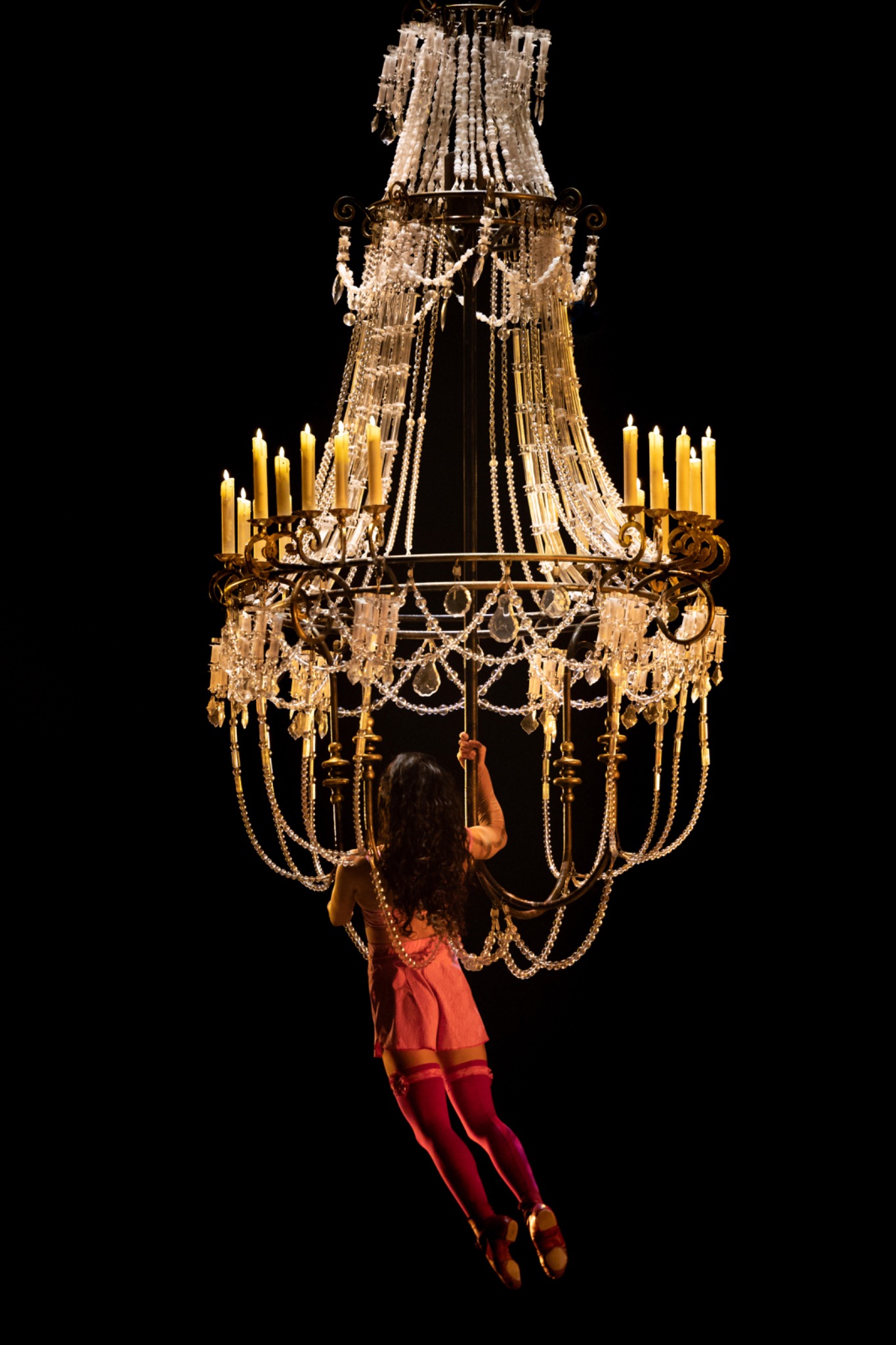 Acrobate suspendue à un lustre monumental