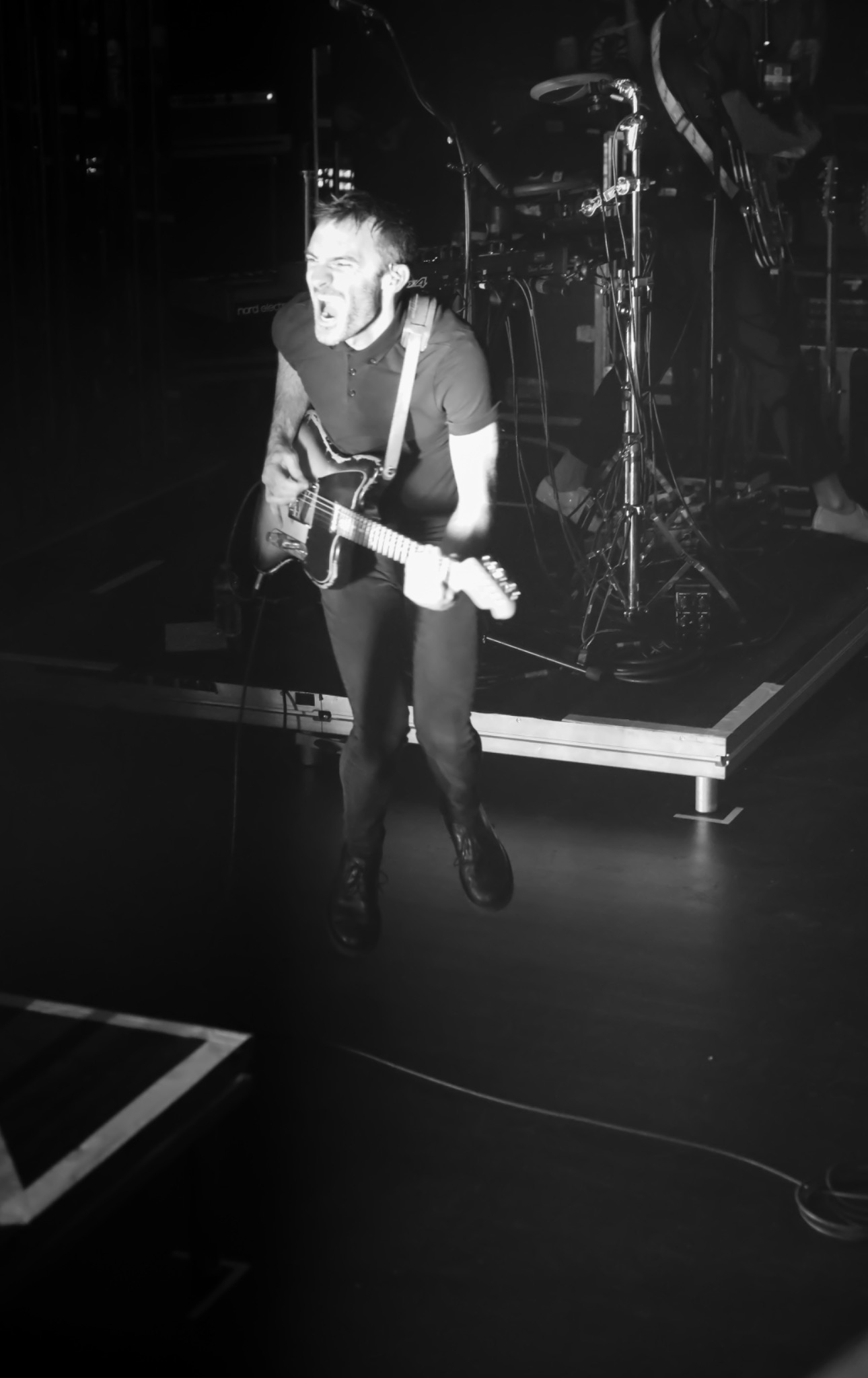 Guitariste sur scène en plein concert, photographie noir et blanc