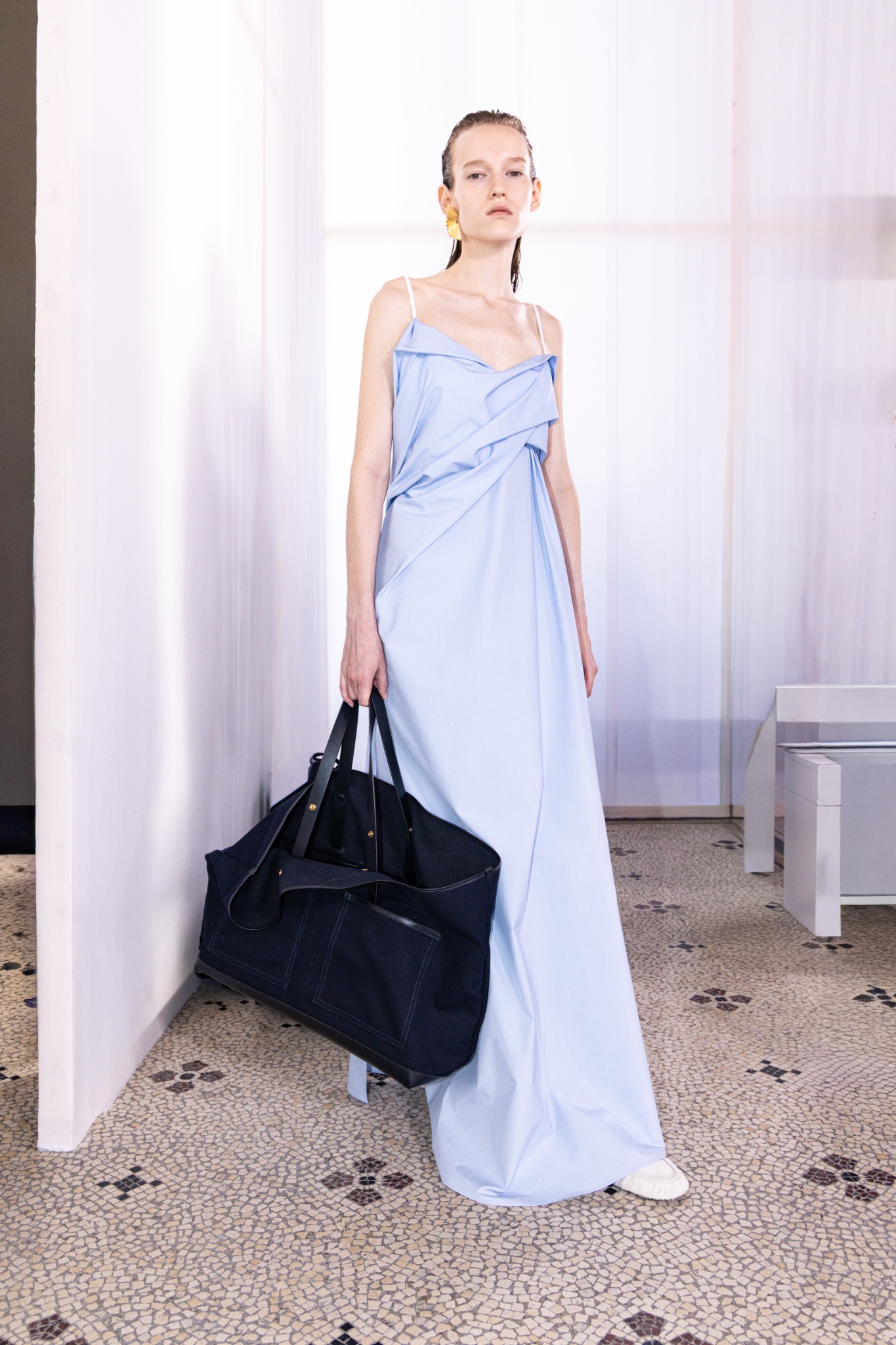 Silhouette de défilé en robe bleue avec un grand sac